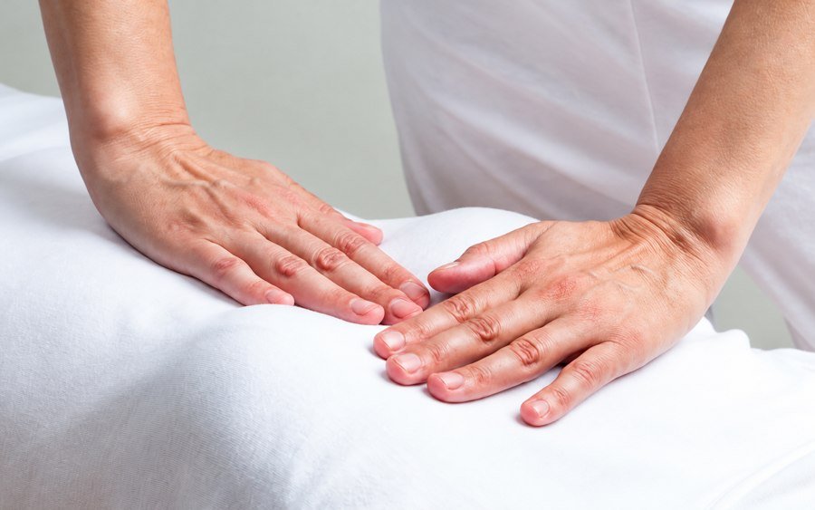 Mains posées délicatement sur le buste d’une personne habillée